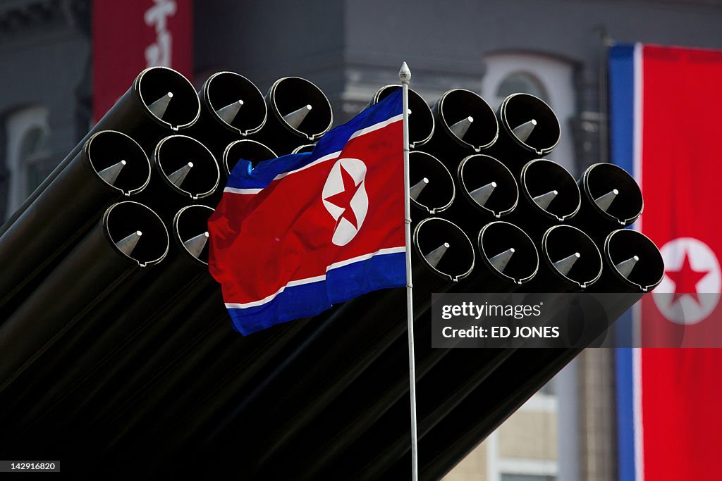 A North Korean flag flies before missile