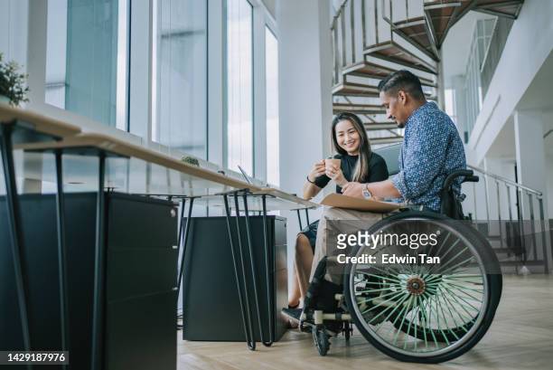 diversify asian indian white collar  worker in wheelchair working together with female colleague in creative office workstation - corporate gender equality stock pictures, royalty-free photos & images