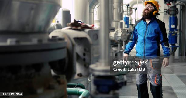 focused heating plant worker in protective clothing. - district heating stock pictures, royalty-free photos & images