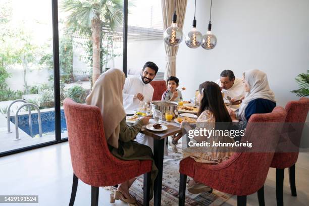 familia saudita de varias generaciones disfrutando juntos de la comida del mediodía - arab family eating fotografías e imágenes de stock