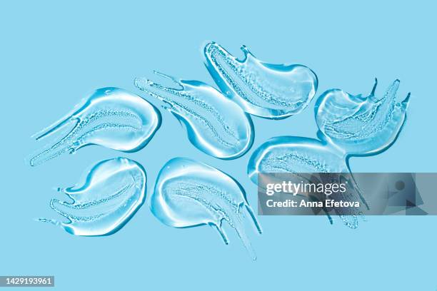 group of transparent gel smears on blue background. also it can be hyaluronic acid, polyglutamic acid or serum with peptides, ceramides, retinol molecules - ointment stock pictures, royalty-free photos & images