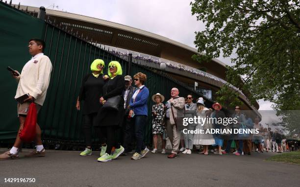 People queue to enter the venue on the first day of the 2023 Wimbledon Championships at The All England Tennis Club in Wimbledon, southwest London,...