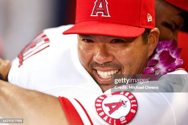 Kurt Suzuki of the Los Angeles Angels hugs his teammate Jo Adell following his retirement ceremony prior to a game against the Texas Rangers at Angel...