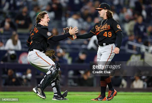 Adley Rutschman and DL Hall of the Baltimore Orioles celebrate the win over the New York Yankees at Yankee Stadium on September 30, 2022 in the Bronx...