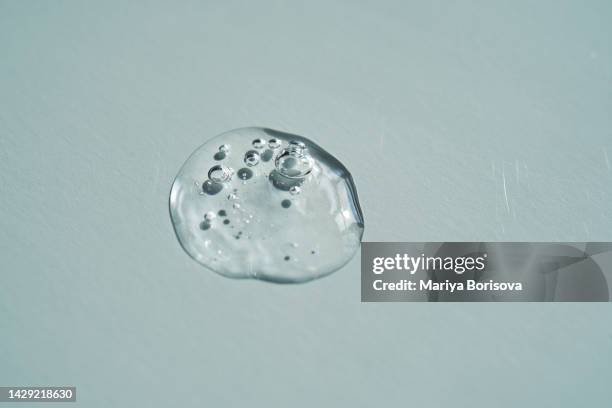 a drop of cosmetic liquid gel or micellar water on a blue background. - organic compound stock pictures, royalty-free photos & images