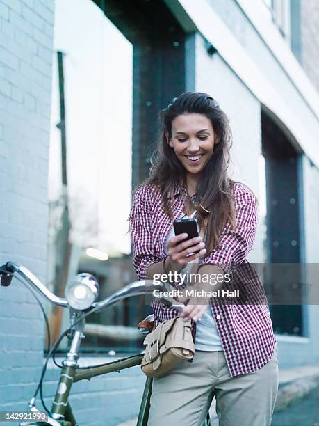 girl with bicycle on phone - person looking at phone while smiling australia stock pictures, royalty-free photos & images