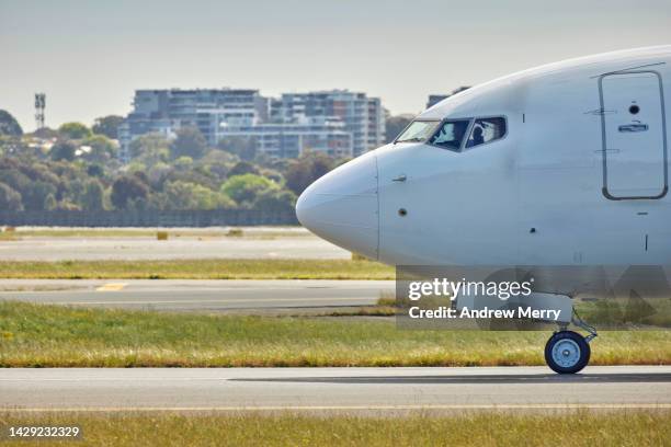 jet airplane close up, runway and urban city skyline - taxiing stock pictures, royalty-free photos & images