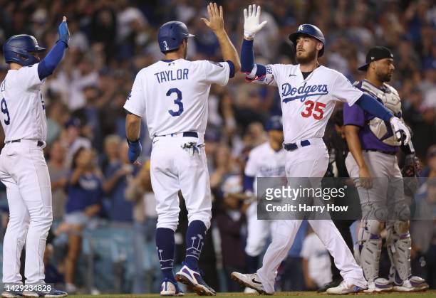 Cody Bellinger of the Los Angeles Dodgers celebrates his three run homerun with Chris Taylor and Gavin Lux in front of Elias Diaz of the Colorado...