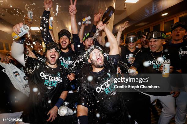 Eugenio Suarez of the Seattle Mariners celebrates with teammates in the clubhouse after clinching a postseason birth after beating the Oakland...