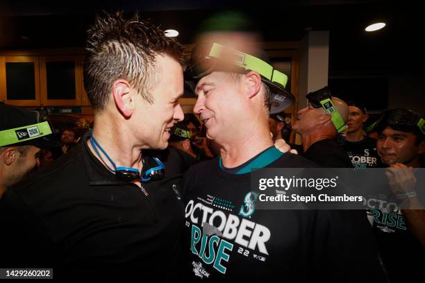 General manager Jerry Dipoto and Scott Servais of the Seattle Mariners celebrate in the clubhouse after clinching a postseason birth after beating...