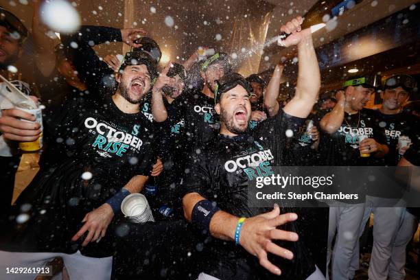 Eugenio Suarez of the Seattle Mariners celebrates with teammates in the clubhouse after clinching a postseason birth after beating the Oakland...