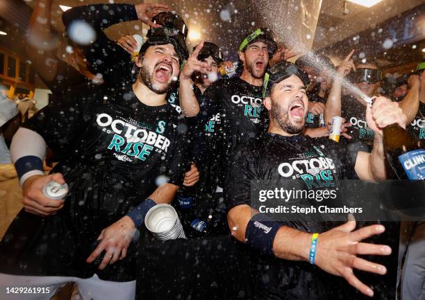 Eugenio Suarez of the Seattle Mariners celebrates with teammates in the clubhouse after clinching a postseason birth after beating the Oakland...