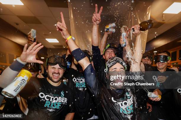 Eugenio Suarez of the Seattle Mariners celebrates with teammates in the clubhouse after clinching a postseason birth after beating the Oakland...