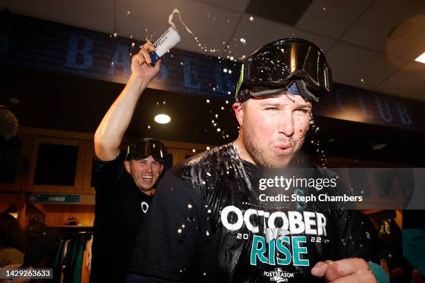 Ty France of the Seattle Mariners celebrates with teammates in the clubhouse after clinching a postseason birth after beating the Oakland Athletics...