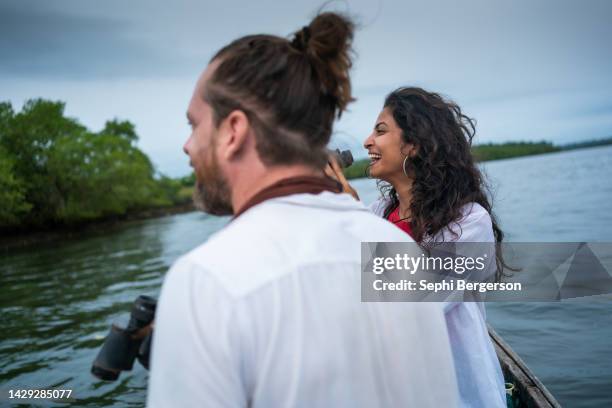 couple bird watching on a river boat - bird watching stock pictures, royalty-free photos & images