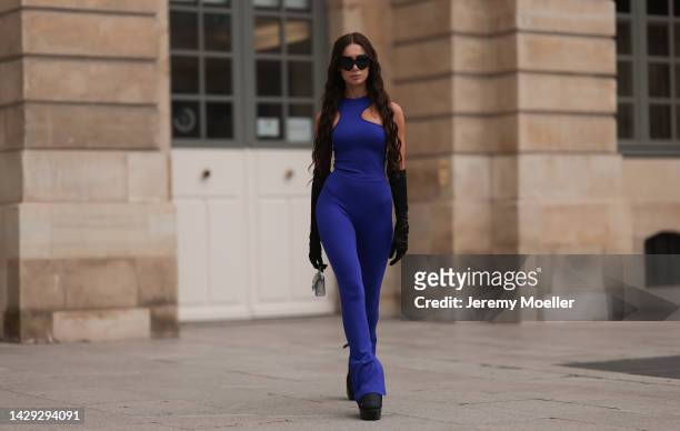 Sabina Jakubowicz seen wearing Balmain black bold boots, Balenciaga mini silver shiny Hourglass bag and black shades, Off White blue logo top and...
