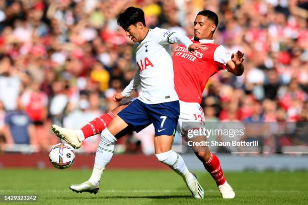 Son Heung-Min of Tottenham Hotspur is challenged by William Saliba of Arsenal during the Premier League match between Arsenal FC and Tottenham...