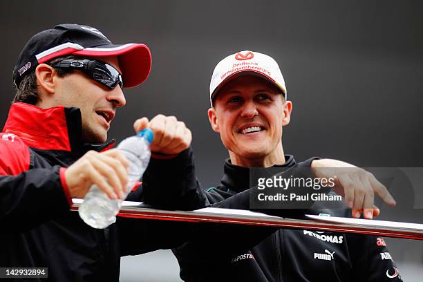 Timo Glock of Germany and Marussia talks with Michael Schumacher of Germany and Mercedes GP at the drivers parade before the Chinese Formula One...