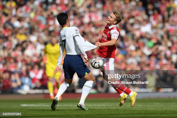 Son Heung-Min of Tottenham Hotspur is challenged by Martin Oedegaard of Arsenal during the Premier League match between Arsenal FC and Tottenham...