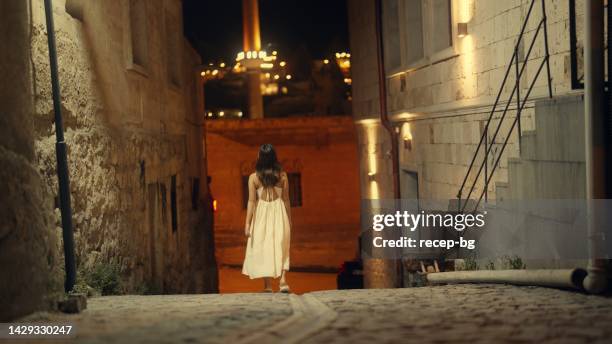 young woman walking in small alley at night - evening walk stock pictures, royalty-free photos & images