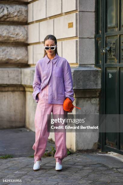 Jenny Tsang in Suet wears white puffy sunglasses from Loewe, silver earrings, a silver large chain necklace, a purple denim shirt from Loewe, pale...