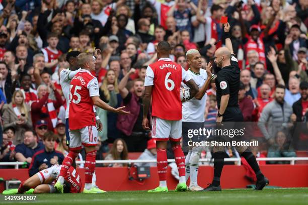 Match referee Anthony Taylor shows a red card to Emerson Royal of Tottenham Hotspur during the Premier League match between Arsenal FC and Tottenham...