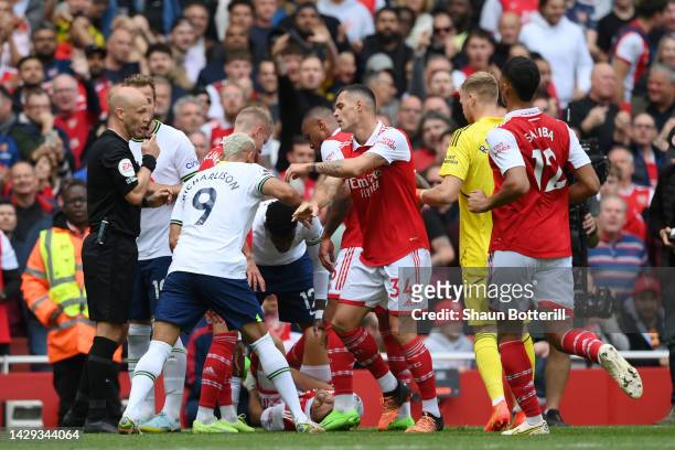 Match referee Anthony Taylor shows a red card to Emerson Royal of Tottenham Hotspur during the Premier League match between Arsenal FC and Tottenham...