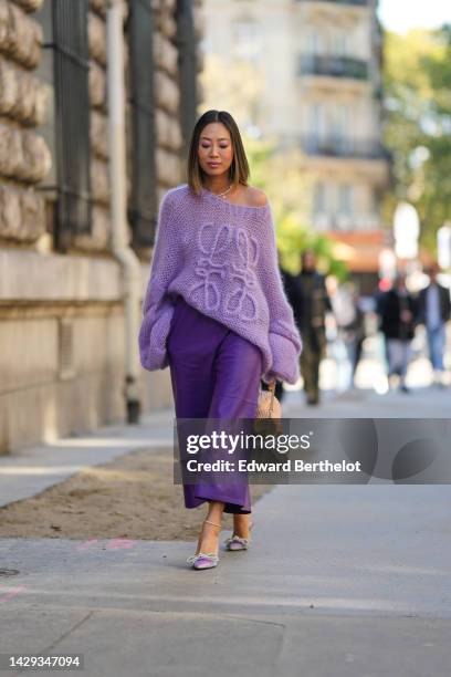 Aimee Song wears gold and pearl pendant earrings, a white pearls necklace, a pale purple wool with embroidered large logo oversized pullover from...