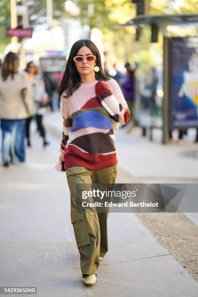 Guest wears beige sunglasses from Miu Miu, a pale pink / brown / red / blue print pattern wool pullover, a pale yellow leather shoulder bag, silver...