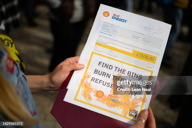 Protestor shows a stack of fake energy bills before they are burnt during a protest against the increased price of energy bills, on October 01, 2022...