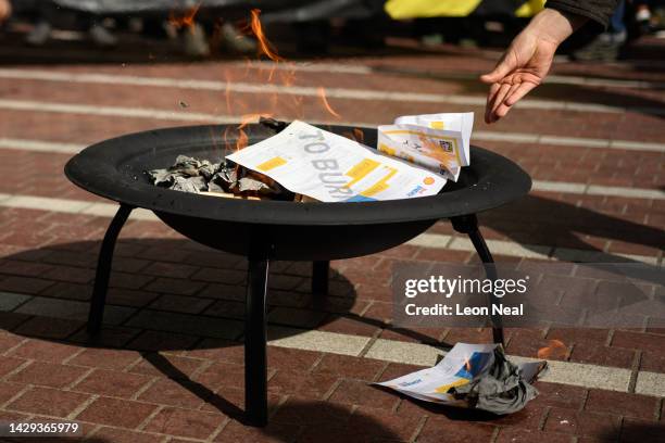 Protesters put fake energy bills onto a fire during a protest against the increased price of energy bills, on October 01, 2022 in Birmingham,...