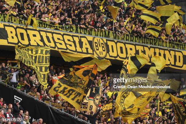 Borussia Dortmund fans wave flags to show their support during the Bundesliga match between 1. FC Köln and Borussia Dortmund at RheinEnergieStadion...