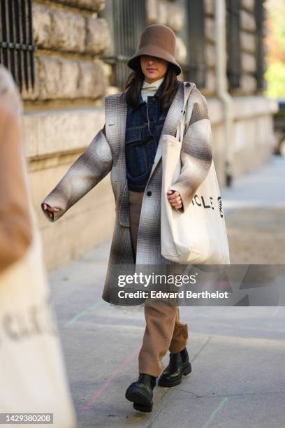 Guest wears a brown felt wool high hat, a white latte turtleneck pullover, a navy blue denim jacket, a gray / beige / white checkered print pattern...