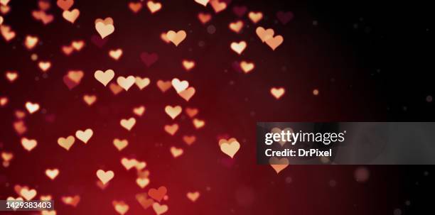 glowing hearts on red gradient background - heart bokeh stock pictures, royalty-free photos & images