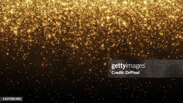 glittering golden particles - glittering foto e immagini stock