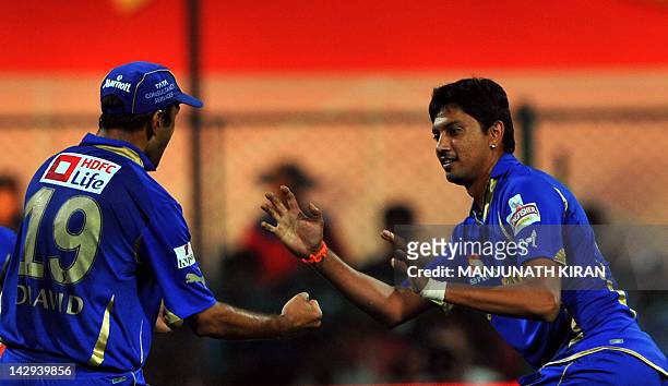 Rajasthan Royals bowler Siddharth Trivedi celebrates the wicket of Royal Challengers Bangalore batsman A.B. DeVilliers with his captain Rahul Dravid...