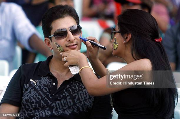 Kolkata Knight Riders fan couple busy in face painting during the IPL 5 cricket match played between Kings XI Punjab and Kolkata Knight Riders at...