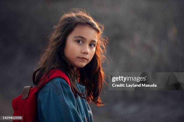 school girl with red backpack - girl looking over shoulder stock pictures, royalty-free photos & images