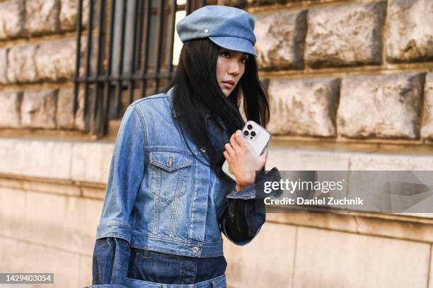 Yoyo Cao is seen wearing a denim jacket and pants with a denim hat and light blue Loewe bag outside the Loewe show during Paris Fashion Week S/S 2023...