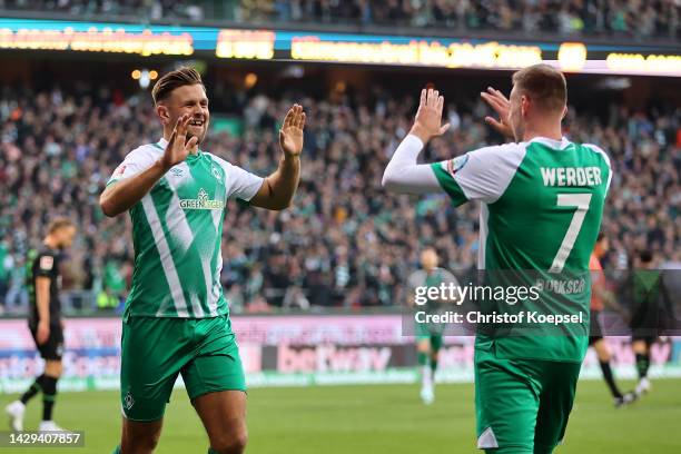 Niclas Fullkrug of Werder Bremen celebrates with teammate Marvin Ducksch after scoring their team's third goal during the Bundesliga match between SV...