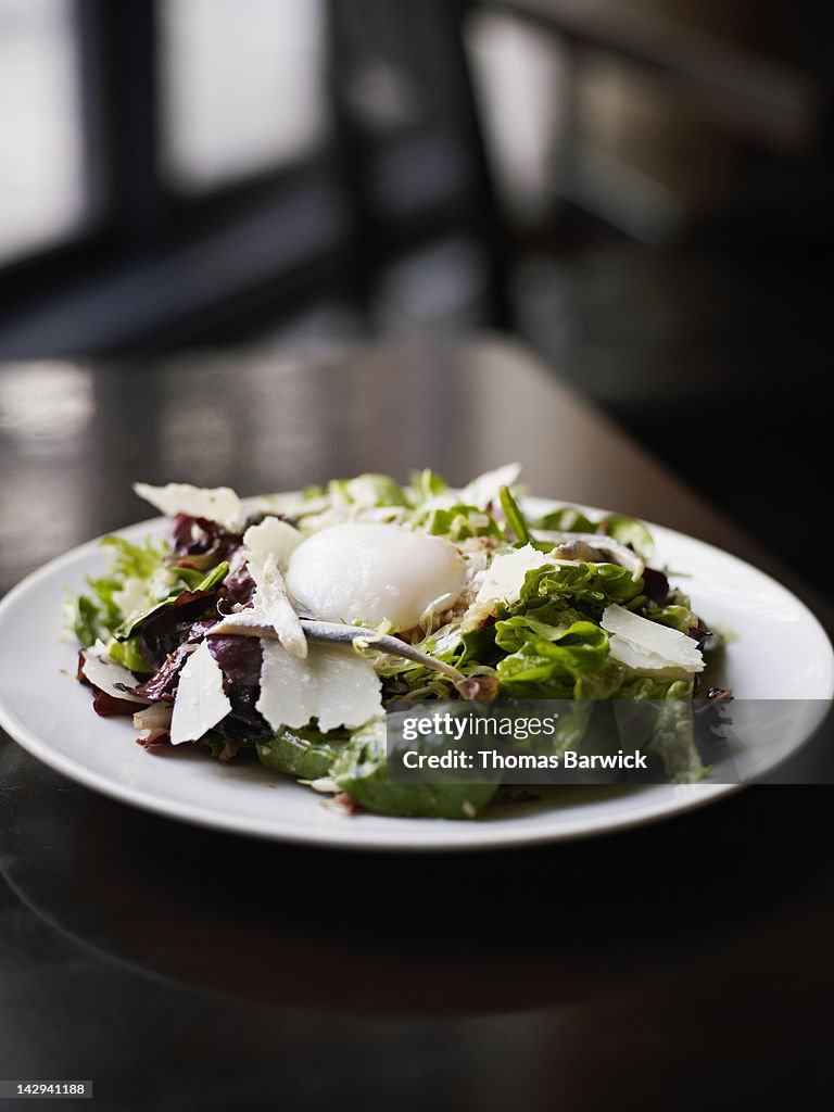Baby lettuce salad topped with soft boiled egg