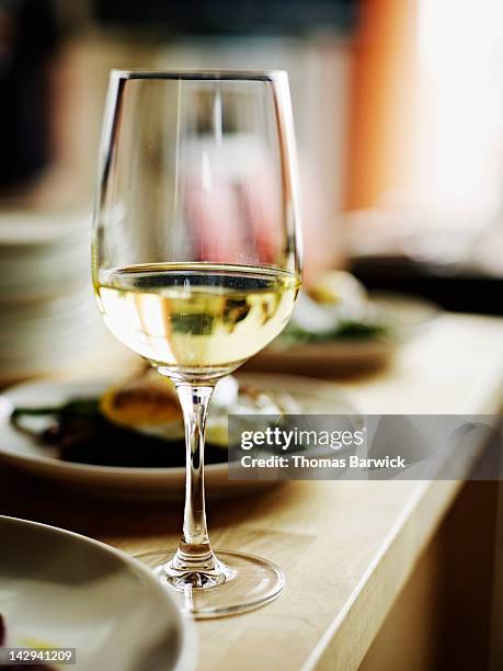 glass of white wine sitting on countertop - white wine stock-fotos und bilder