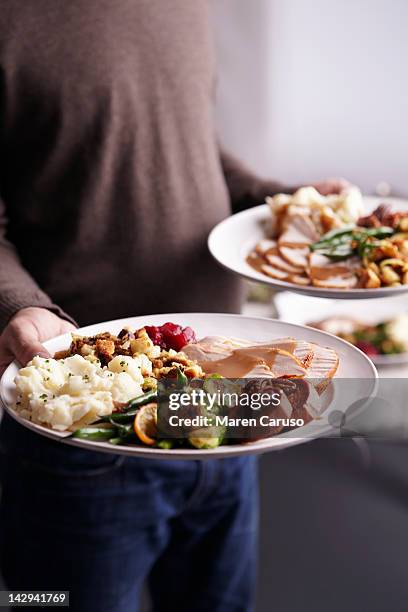 man holding two plates served with a turkey meal - service of thanksgiving stock pictures, royalty-free photos & images