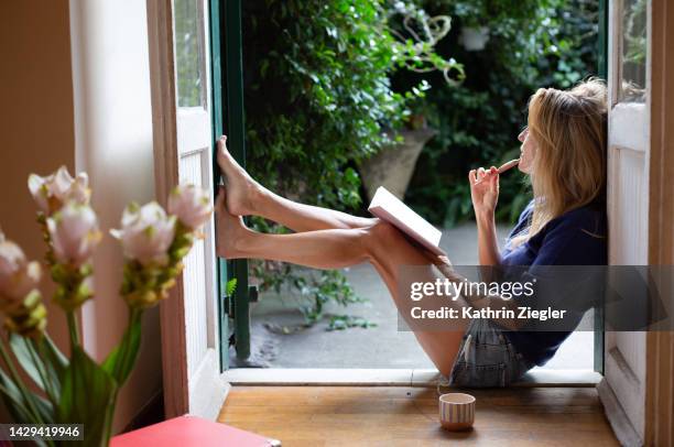 woman leaning on doorway, writing in notebook - relaxation 個照片及圖片檔