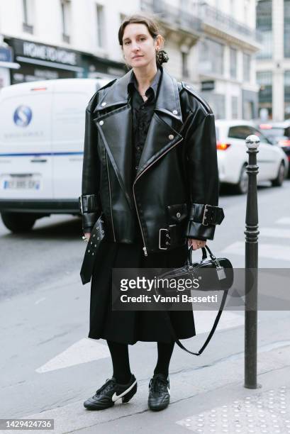 Guest poses wearing a Vaquera faux leather oversized moto jacket, Vaquera violin shaped tote bag and Comme des Garcons X Nike shoes after the Noir...