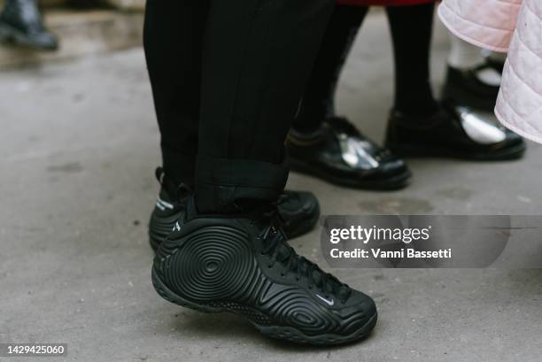 Guest poses wearing Comme des Garcons Homme plus X Nike sneakers after the Noir Kei Ninomiya show at the Oratoire du Louvre during Paris Fashion Week...