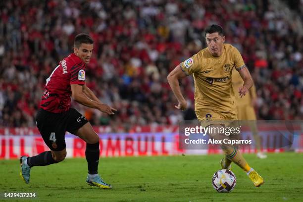 Robert Lewandowski of FC Barcelona runs with the ball while under pressure from Inigo Ruiz de Galarreta of RCD Mallorca during the LaLiga Santander...