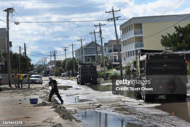 Workers attempt to recover sand from roads that were deposited during Hurricane Ian on October 1, 2022 in Garden City Beach, South Carolina. Ian hit...