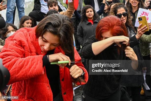 Two women cut their hair as protesters gather in Manhattan to show their opposition to the Iranian regime following the death of Mahsa Amini, a...