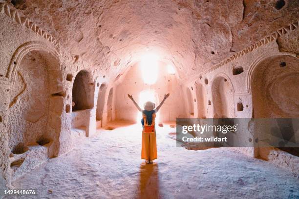 traveler young girl is opening her arms inside a cave church in zelve ancient city at cappadocia in nevsehir , turkey - rock hoodoo stock pictures, royalty-free photos & images